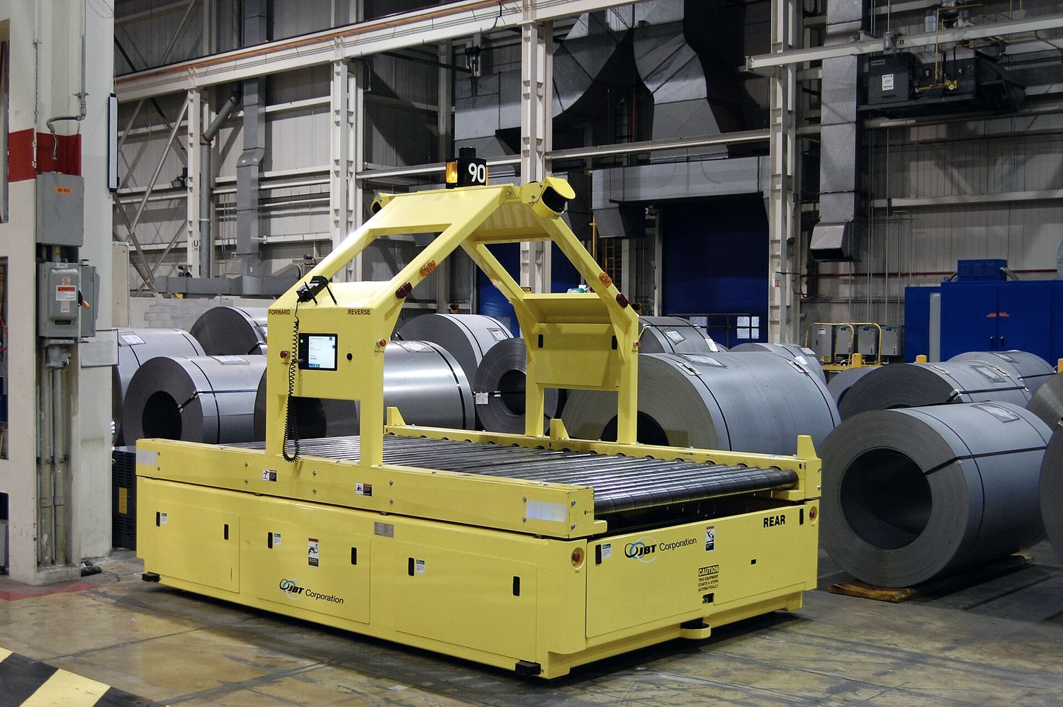 Veículo autônomo de carga movimentando bobinas dentro de uma planta industrial