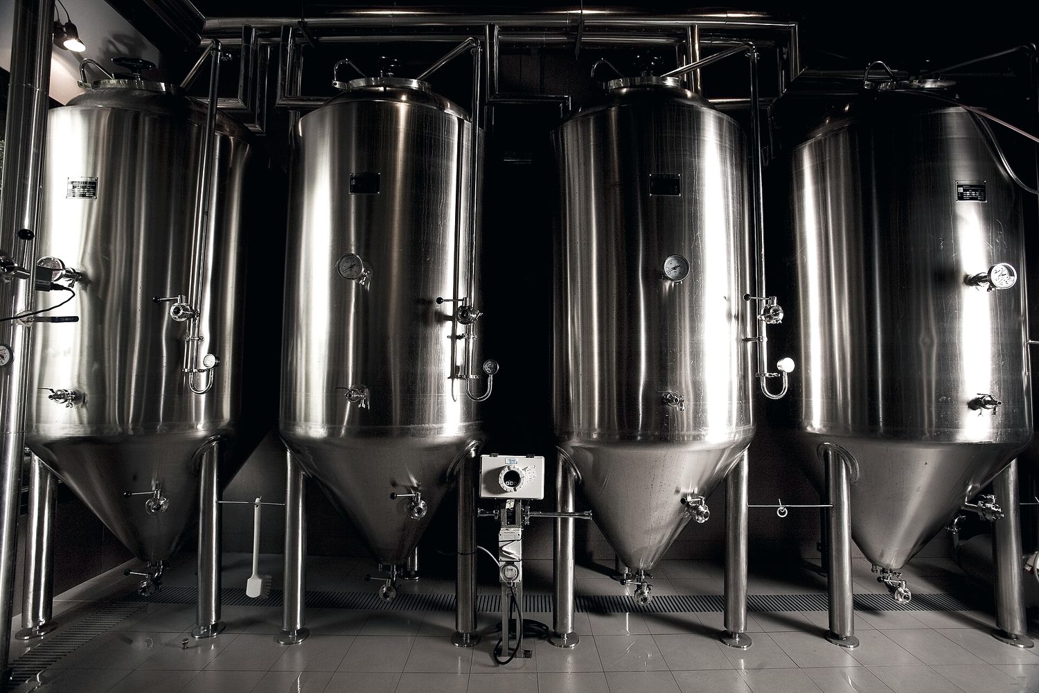 Tanques de fermentação em aço inoxidável numa planta industrial de bebidas